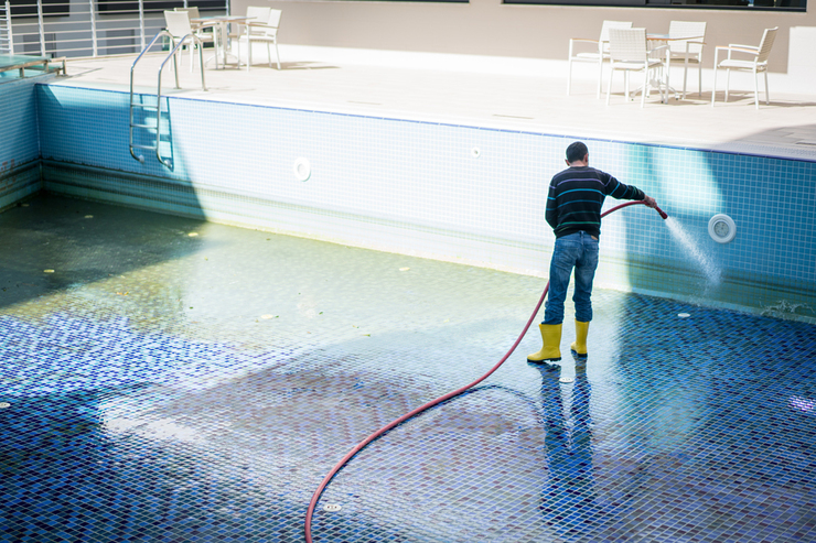 Hombre limpieando piscina sucia